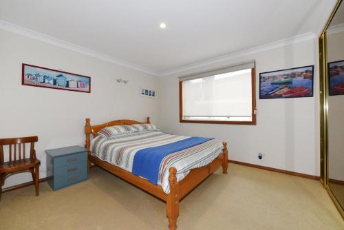a bedroom with a bed and a window at Aqua Vincentia - Belle Escapes Jervis Bay in Vincentia