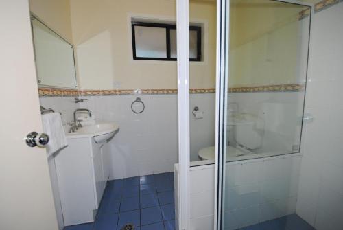 ein Badezimmer mit Dusche, Toilette und Waschbecken in der Unterkunft Beachfront Unit - Belle Escapes Jervis Bay in Vincentia