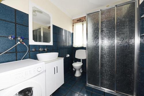 a bathroom with a sink and a washing machine at Excellent Location - Belle Escapes Jervis Bay in Vincentia