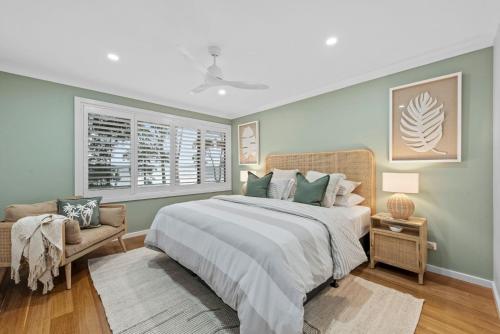 a bedroom with a large bed and a chair at Edge Water - Belle Escapes Jervis Bay in St Georges Basin