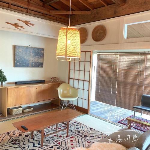 a living room with a table and a chair at &stay Mitsubishiso - Vacation STAY 16488v in Miyakami