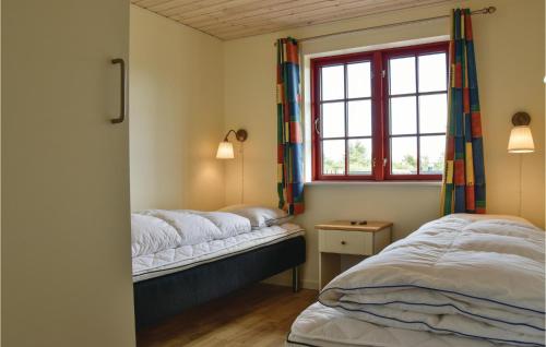 リンケビングにあるAwesome Home In Ringkbing With 2 Bedrooms And Wifiのベッドルーム1室(ベッド2台、窓付)