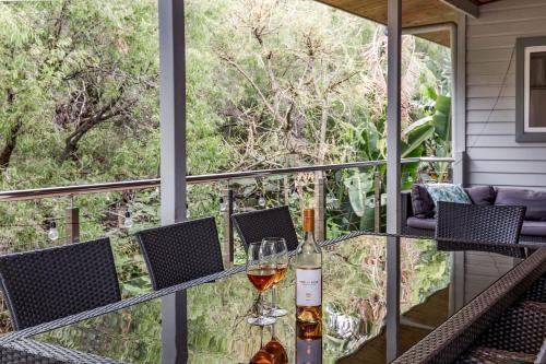 a table with two glasses of wine on a balcony at Melaleuca in Dunsborough