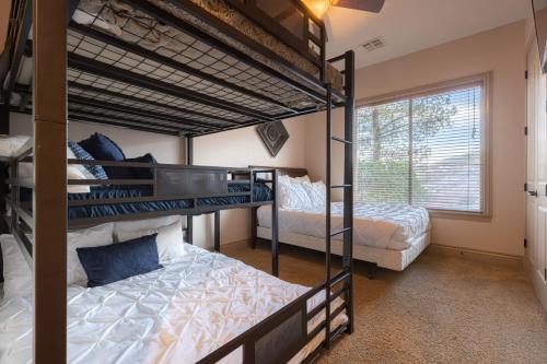 a bedroom with three bunk beds and a window at D5-Coral Springs Poolside-Ground Floor 3-bedroom Hillside View in Hurricane