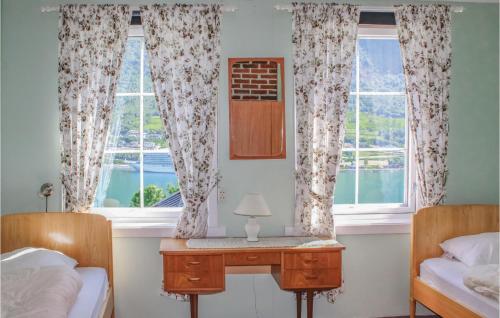 a bedroom with two beds and a desk in front of two windows at Amazing Home In Olden With 4 Bedrooms And Wifi in Olden