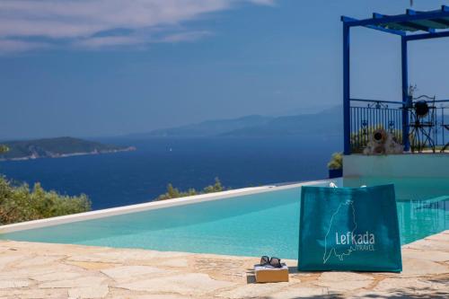 a shopping bag sitting next to a swimming pool at Villa Careva - Beautiful Cozy and Luxury Villa in Sivota