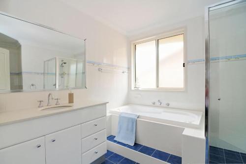 a white bathroom with a sink and a mirror at Spectacular - Belle Escapes Jervis Bay in Vincentia
