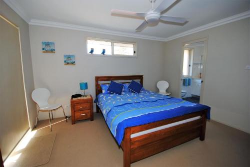a bedroom with a bed and a ceiling fan at Spectacular - Belle Escapes Jervis Bay in Vincentia