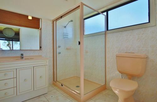 Un baño con ducha, inodoro y lavabo. en Absolute Waterfront - Belle Escapes Jervis Bay, en St Georges Basin