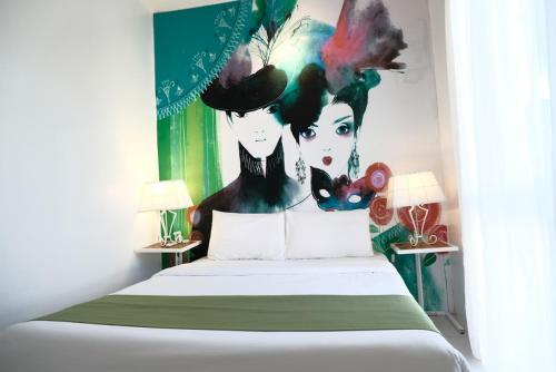 a bedroom with a bed with a painting on the wall at La Bella Boutique Hotel in Tagaytay