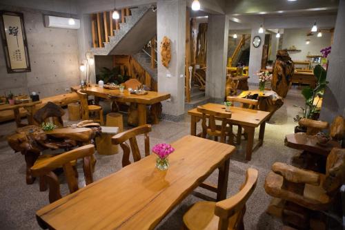 a restaurant with wooden tables and wooden chairs at Water Reflections at Ease in Donggang