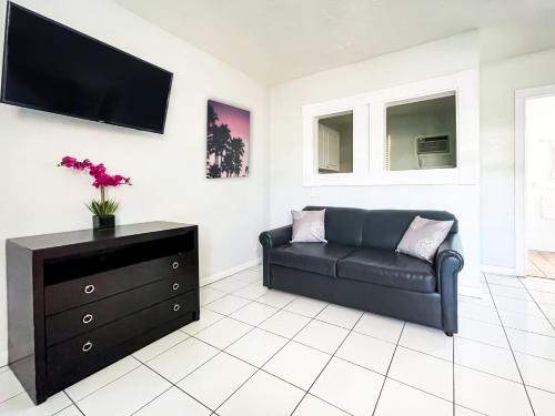 a living room with a couch and a tv on a wall at The Swan in Hollywood