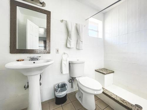 a white bathroom with a toilet and a sink at The Swan in Hollywood