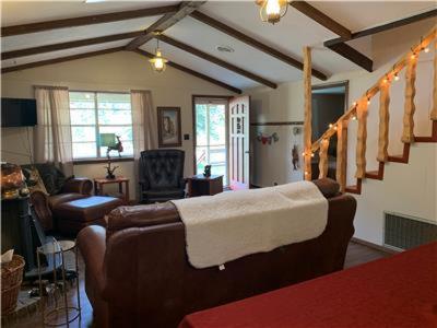 a living room with a couch and a staircase at Cozy Bear - Upper Valley With High Speed Wifi in Red River