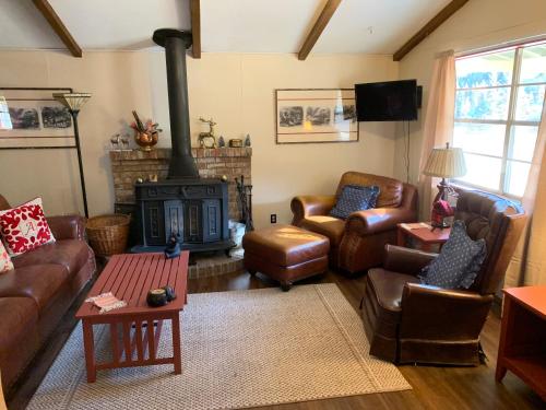 a living room with leather furniture and a fireplace at Cozy Bear - Upper Valley With High Speed Wifi in Red River
