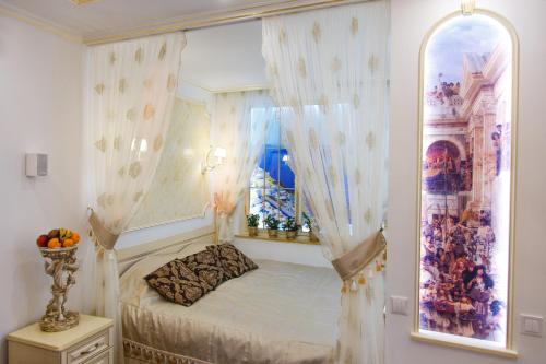 a bedroom with a canopy bed with a window at Versal Apartments in Kremenchuk
