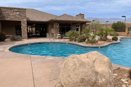 a swimming pool with a rock in front of a house at H7-Heavenly-Ground Floor 3-bedroom Hillside View in Hurricane