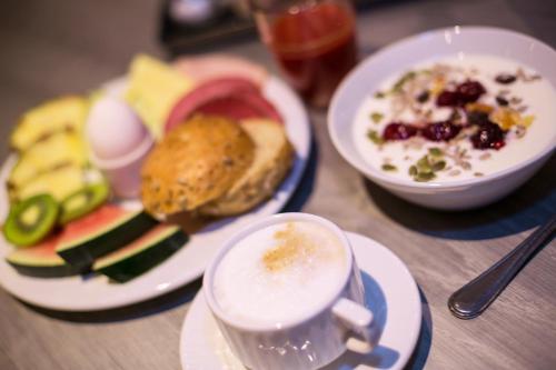 a table with plates of food and a cup of coffee at Hotell Östersund in Östersund