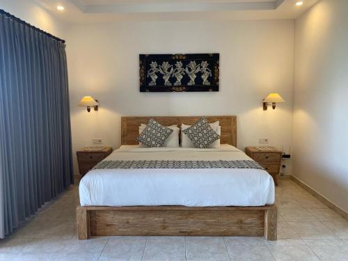 a bedroom with a large bed and two night stands at Lembongan Lux Villas in Klungkung
