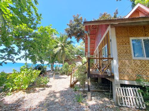 a house with a balcony next to the beach at Paseo Del Mar Seaside Inn in Jagna