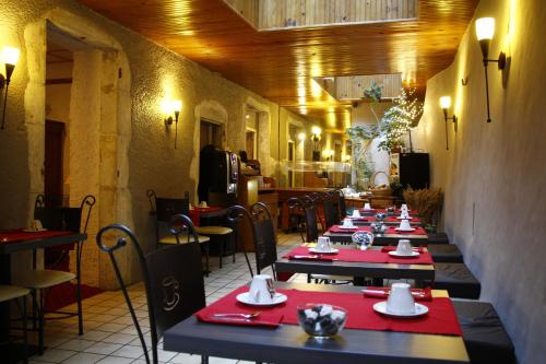 una fila de mesas en un restaurante con servilletas rojas en Hotel des Marquisats en Annecy