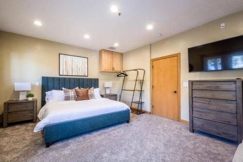 a bedroom with a large bed and a flat screen tv at Majestic Suite 5 Bedroom Brighton Chalet in Brighton