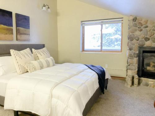 a bedroom with a white bed and a fireplace at Majestic Suite 5 Bedroom Brighton Chalet in Brighton