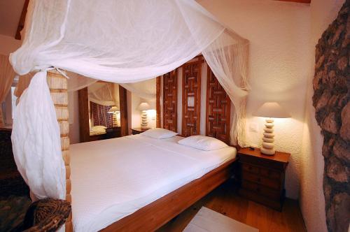 1 dormitorio con cama con dosel y sábanas blancas en Boutique Hotel Placa en Krk