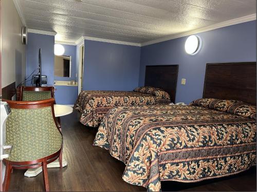 Habitación de hotel con 2 camas y mesa en Spanish Inn Motel en Brookhaven