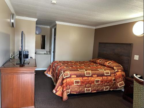 Habitación de hotel con cama y TV en Spanish Inn Motel en Brookhaven