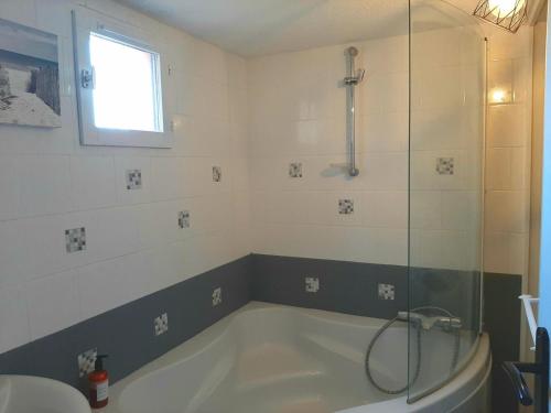 une baignoire dans une salle de bain avec douche dans l'établissement Duplex cosy avec piscine et parking à Capbreton - FR-1-239-870, à Capbreton