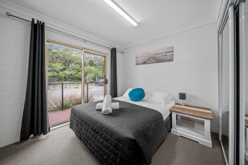 a bedroom with a bed and a large window at Haven Holiday Resort Sussex Inlet in Sussex inlet