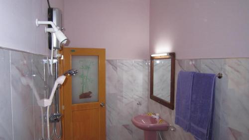 a bathroom with a shower and a sink and a mirror at Hotel Gayan's in Udawalawe