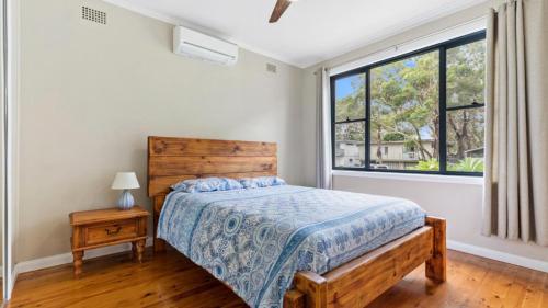 a bedroom with a bed and a window at Beach Heaven in Hawks Nest