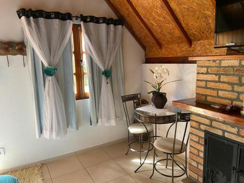 - un salon avec une table et une cheminée dans l'établissement Flor da Montanha, à Monte Verde