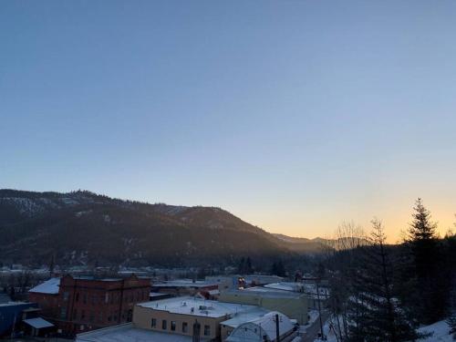 a city with snow on the roofs of buildings and a mountain at Penthouse Studio w Mtn Sunrise Views & Near Silver Mtn in Kellogg