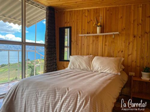 a bedroom with a bed and a large window at La Carreta in Aquitania