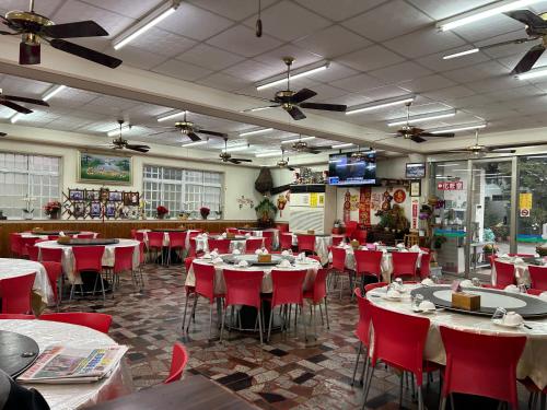 ein Restaurant mit Tischen, Stühlen und roten Stühlen in der Unterkunft Country Homestay in Guoxing
