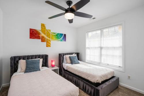 a bedroom with two beds and a ceiling fan at DTPrivacy*KidsFriendly*PetFriendly*300M*Walkable in Raleigh