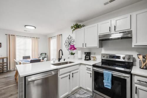 a kitchen with white cabinets and stainless steel appliances at DTPrivacy*KidsFriendly*PetFriendly*300M*Walkable in Raleigh