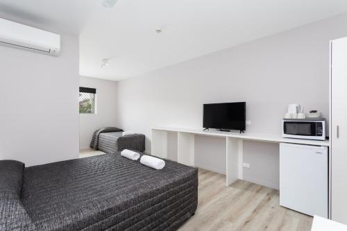 a living room with a couch and a tv at Burleigh Gold Coast Motel in Gold Coast