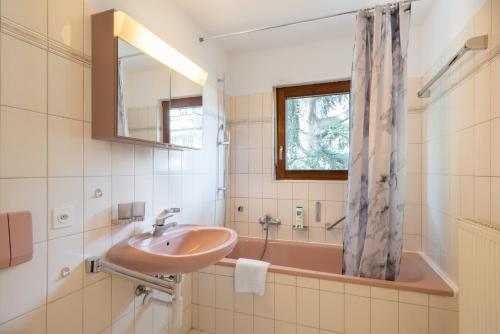 y baño con lavabo y bañera. en Between Lakes Apartments - 58, en Interlaken