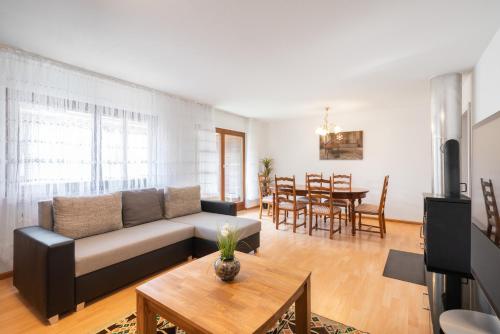 uma sala de estar com um sofá e uma mesa em Between Lakes Apartments - 58 em Interlaken