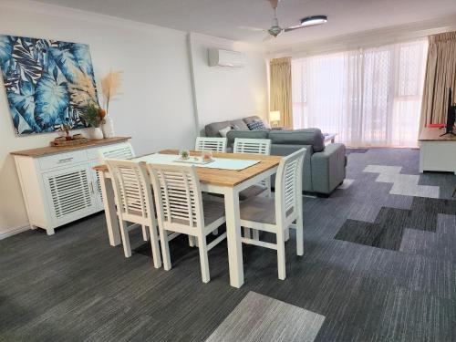 a living room with a table and chairs and a couch at Fairways Golf & Beach Retreat Bribie Island in Woorim