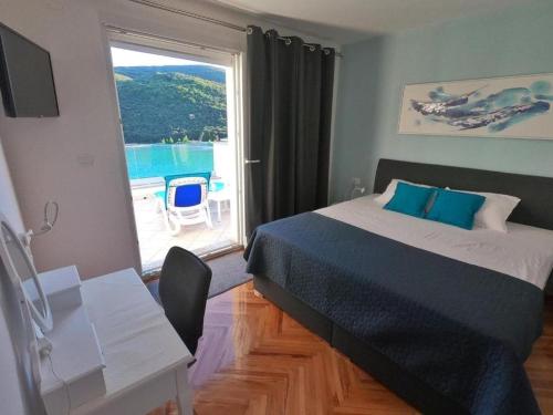 Un dormitorio con una cama y una mesa y una ventana. en Apartment Beautifull View, en Rabac