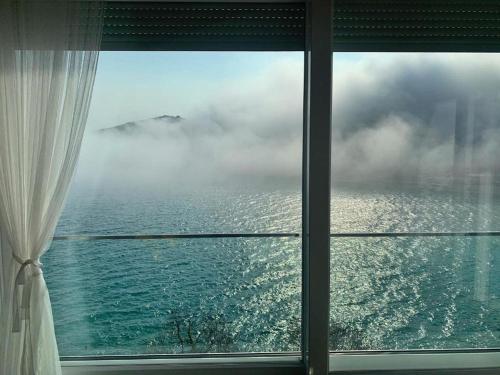 una finestra in una stanza con vista sull'oceano di Apartment Beautifull View a Rabac