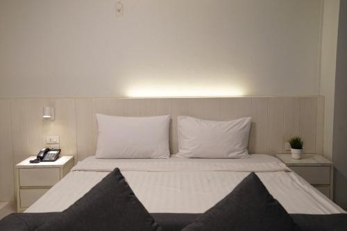 a bedroom with a bed with white sheets and pillows at View Place Hotel & Residence in Bangkok