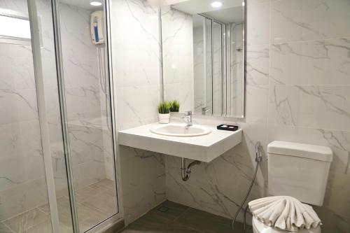 a white bathroom with a sink and a shower at View Place Hotel & Residence in Bangkok