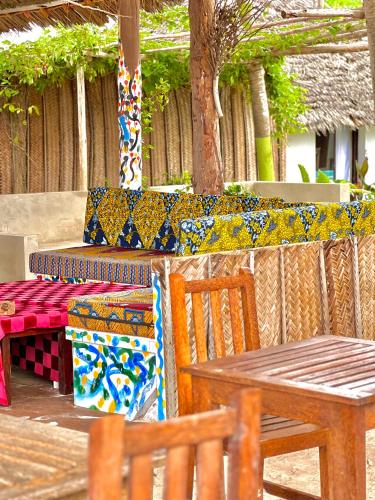 eine Terrasse mit Tisch und Stühlen mit bunten Fliesen in der Unterkunft Jambiani White Sands Bungalows in Jambiani