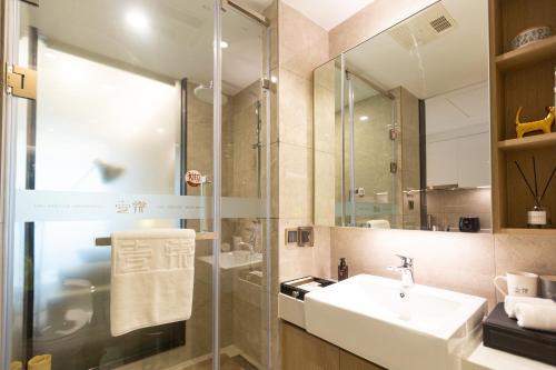 a bathroom with a sink and a shower at Chongqing Yitang Hotel Apartment in Chongqing